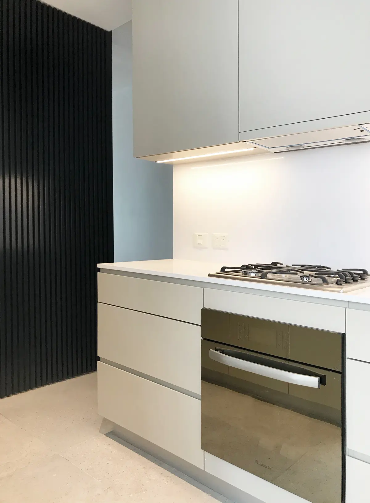 Cocina moderna con pared de lamas negras verticales y mobiliario minimalista — proyecto Scalabrini Ortiz, por Estudio MMS , en CABA