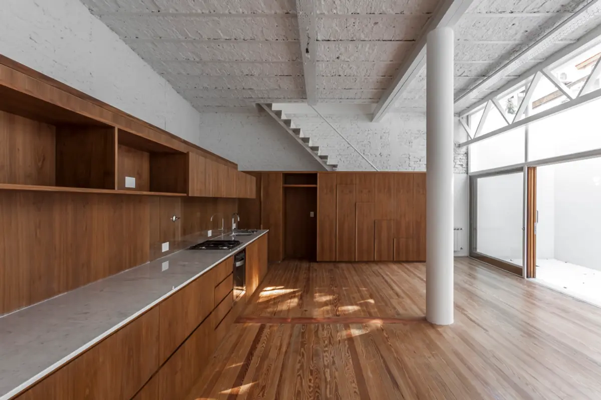 Cozinha moderna com teto de concreto e paredes de madeira — projeto PH Tamborini, por ariana werber arquitecta, em Núñez