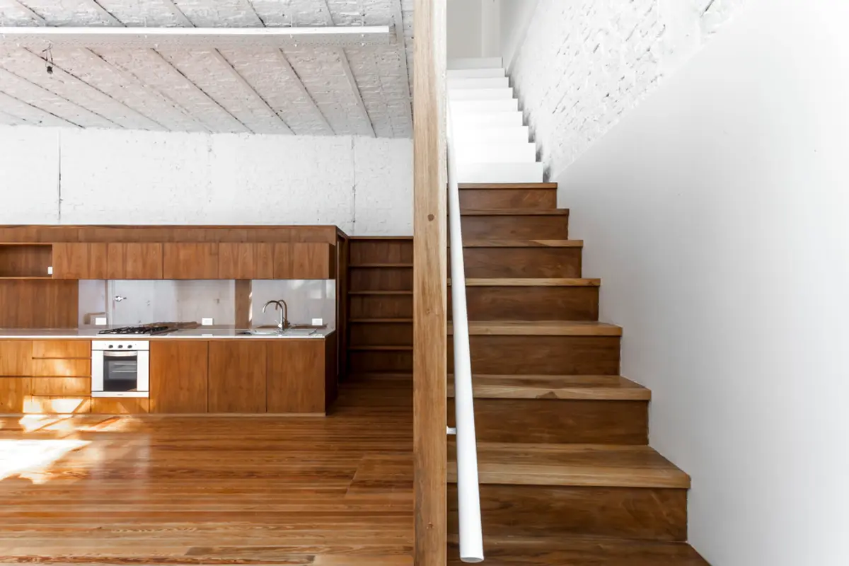 Cozinha moderna com escada flutuante e teto de concreto aparente — projeto PH Tamborini, por ariana werber arquitecta, em Núñez