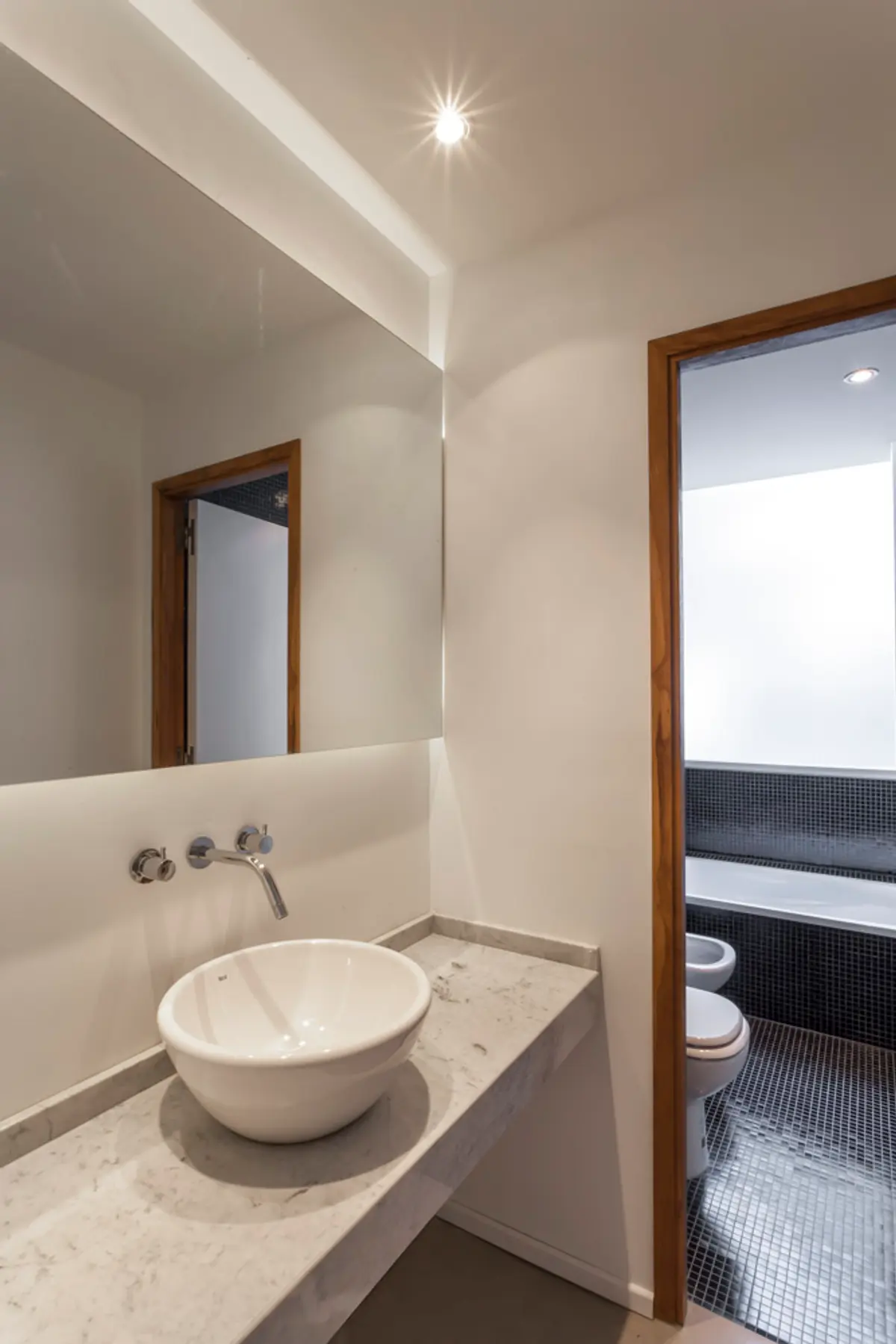 Banheiro moderno minimalista com cuba de apoio e espelho com iluminação — projeto PH Tamborini, por ariana werber arquitecta, em Núñez