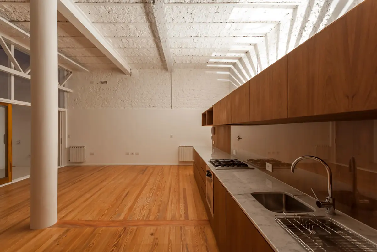 Cocina industrial moderna con techo expuesto y muebles de madera — proyecto PH Tamborini , por ariana werber arquitecta, en Núñez