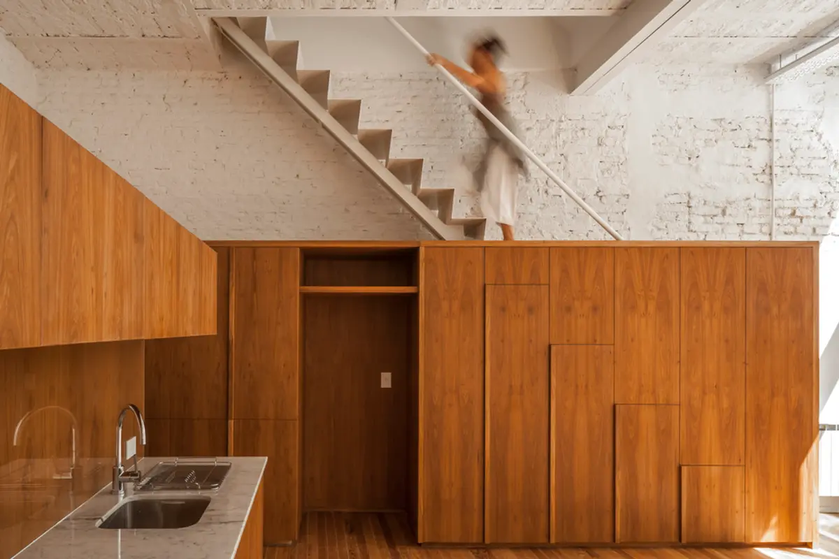 Escalera flotante moderna con muebles de madera y pared de ladrillo expuesto — proyecto PH Tamborini , por ariana werber arquitecta, en Núñez