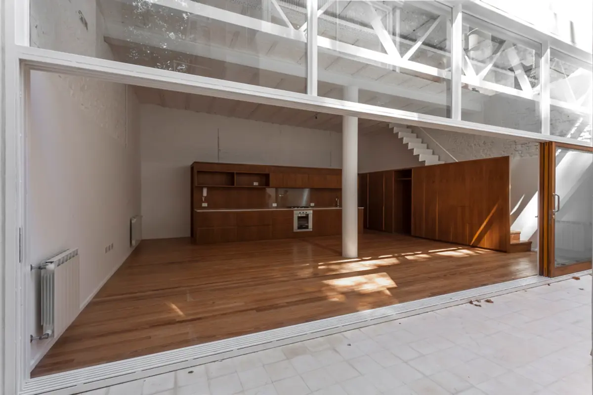 Cozinha moderna com ilha e grandes janelas de madeira — projeto PH Tamborini, por ariana werber arquitecta, em Núñez