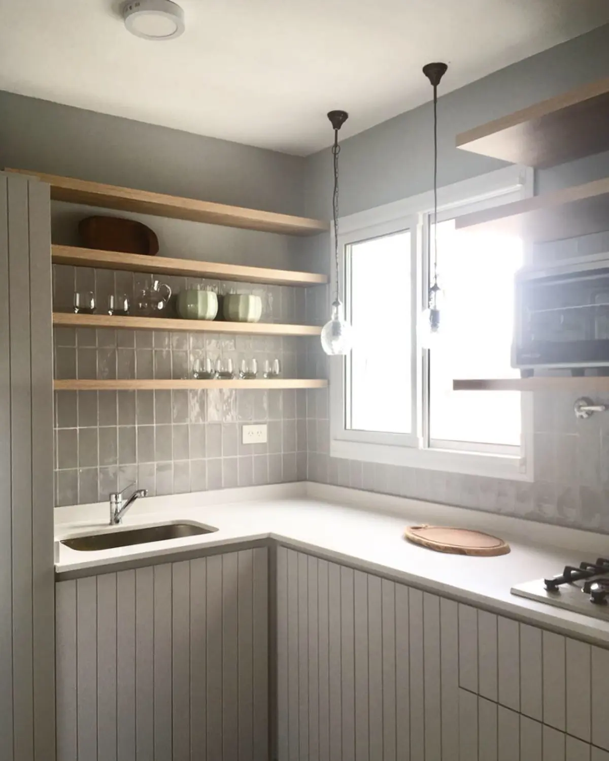 Cocina moderna escandinava con estantes flotantes de madera y muebles blancos — proyecto Av. Santa Fe, por JT ARQUITECTURA, en CABA