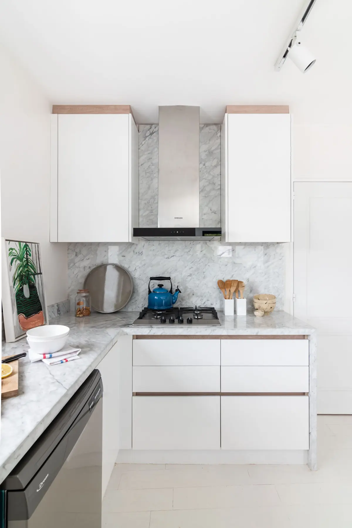 Cocina moderna escandinava con muebles blancos y mármol — proyecto Boating I, por Estudio Arq. Ana M. Carrera, en Boating Club