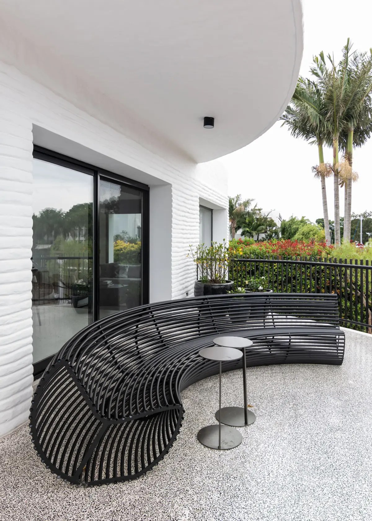 Terraço moderno com sofá curvo preto e parede de tijolos brancos texturizados — projeto Boating I, por Estudio Arq. Ana M. Carrera, em Boating Club