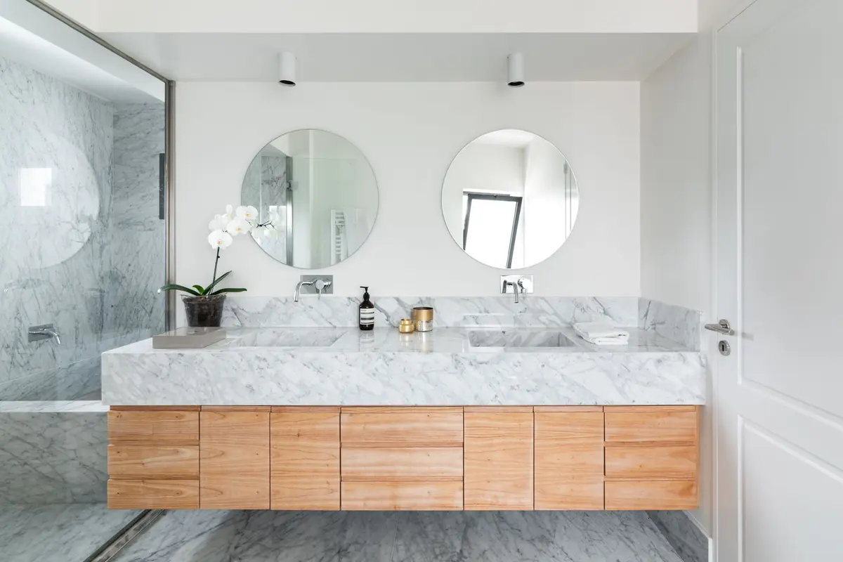 Baño moderno con doble vanitory, mármol y madera flotante — proyecto Boating I, por Estudio Arq. Ana M. Carrera, en Boating Club