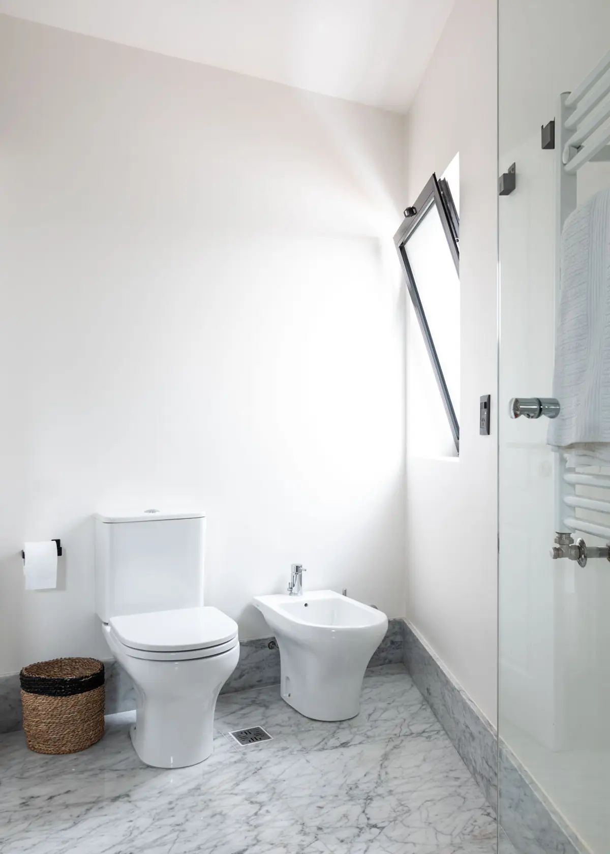 Baño moderno minimalista con suelo de mármol, bidet y claraboya — proyecto Boating I, por Estudio Arq. Ana M. Carrera, en Boating Club