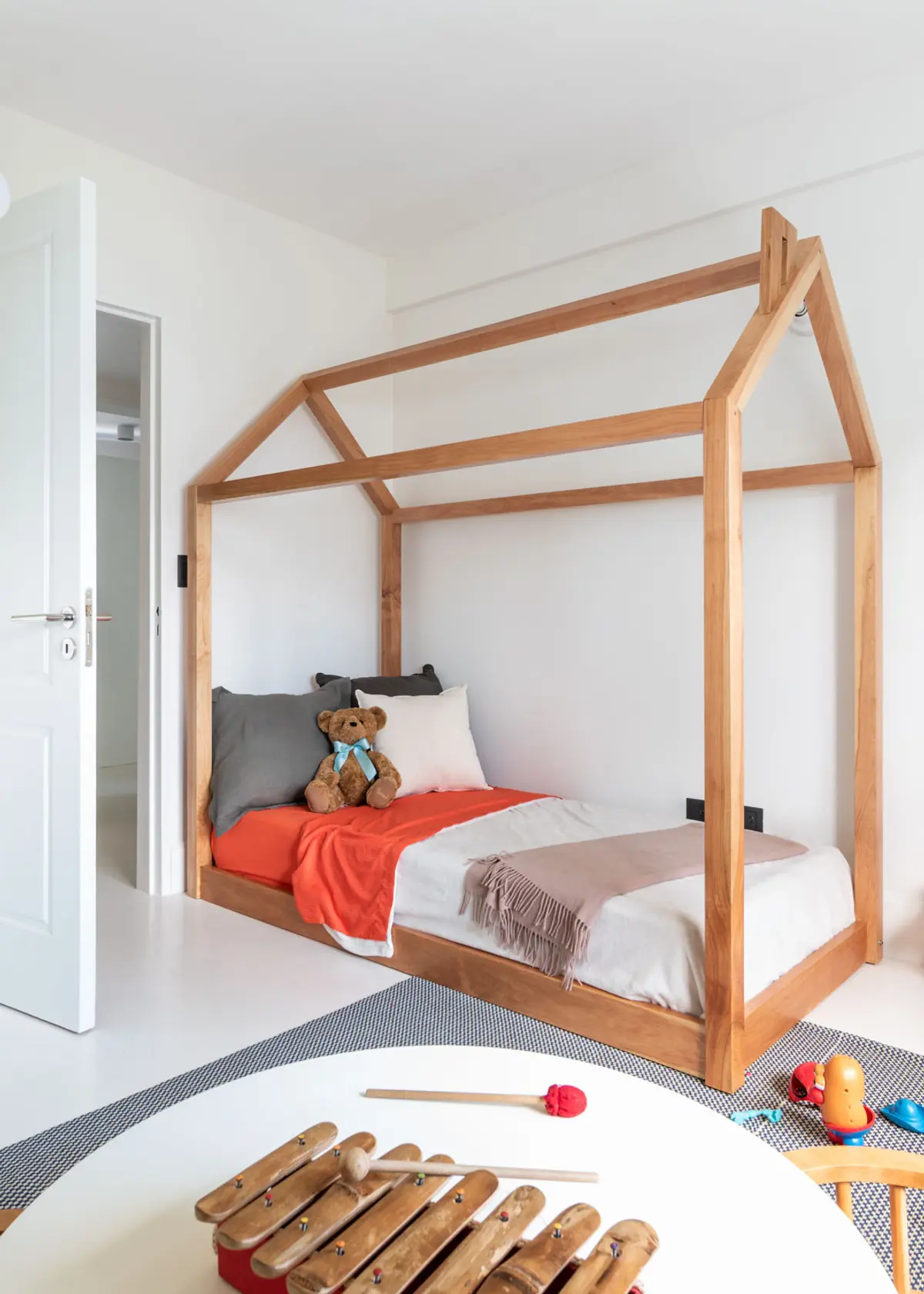 quarto minimalista com cama em formato de casa de madeira — projeto Boating I, por Estudio Arq. Ana M. Carrera, em Boating Club