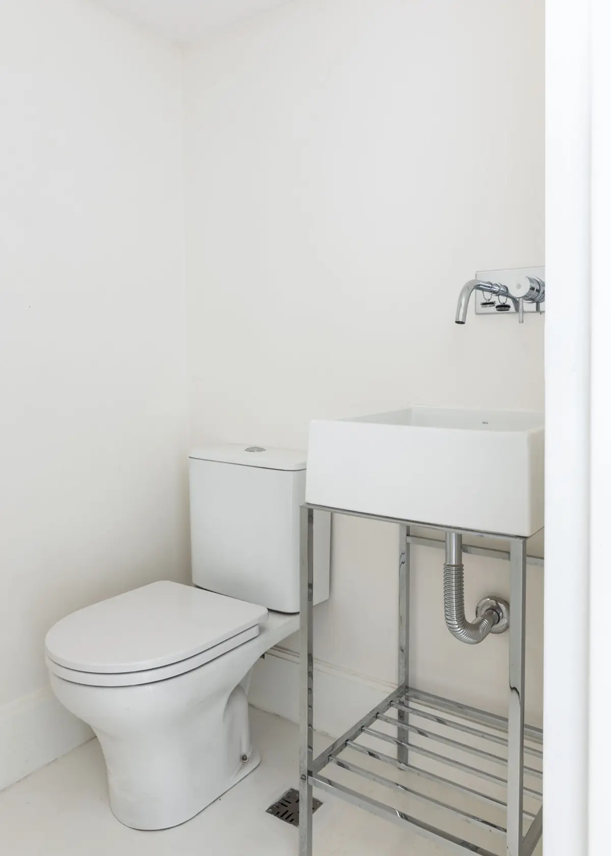 baño minimalista con inodoro y bidet blanco — proyecto Boating I, por Estudio Arq. Ana M. Carrera, en Boating Club