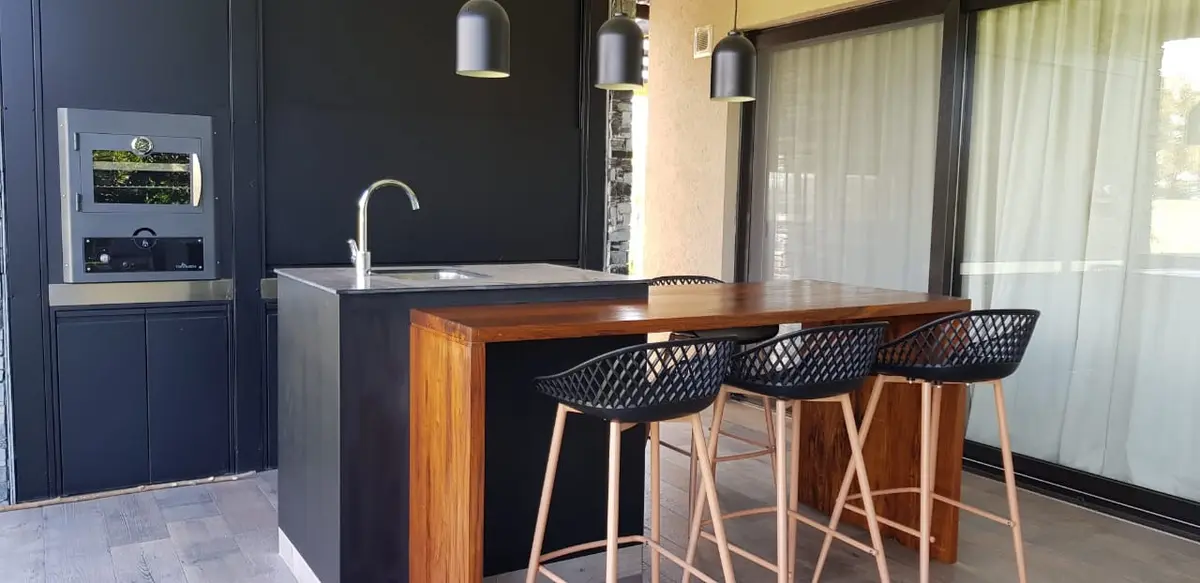 Cocina exterior moderna con isla, barra y heladera de vinos — proyecto HARAS SANTA MARIA, por Ramirez Arquitectura, en Escobar