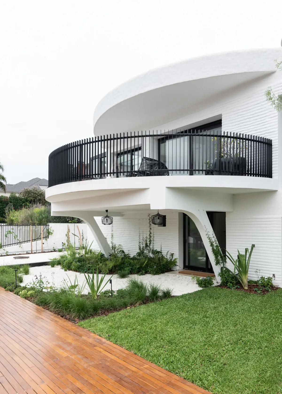 Fachada moderna com varanda curva e vegetação exuberante — projeto Boating I, por Estudio Arq. Ana M. Carrera, em Boating Club