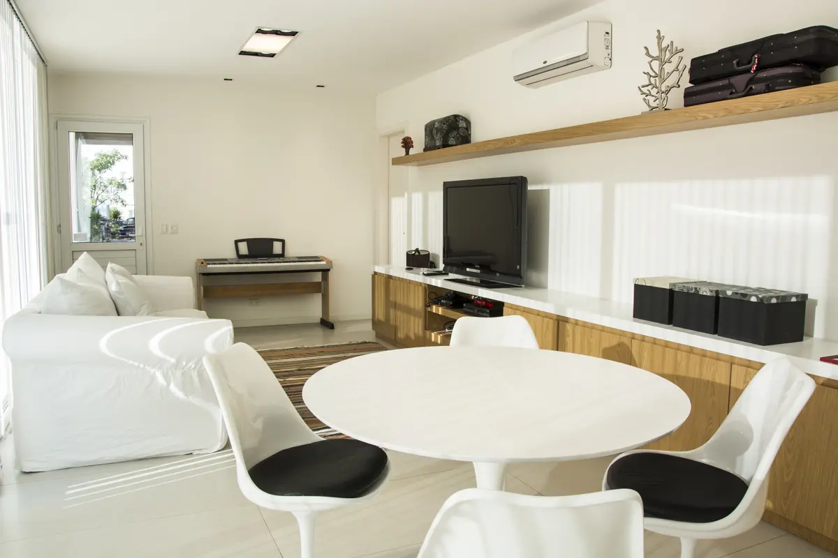 Living comedor moderno con sofá blanco y mesa redonda — proyecto CASA GOLF, por Ramirez Arquitectura, en Nordelta
