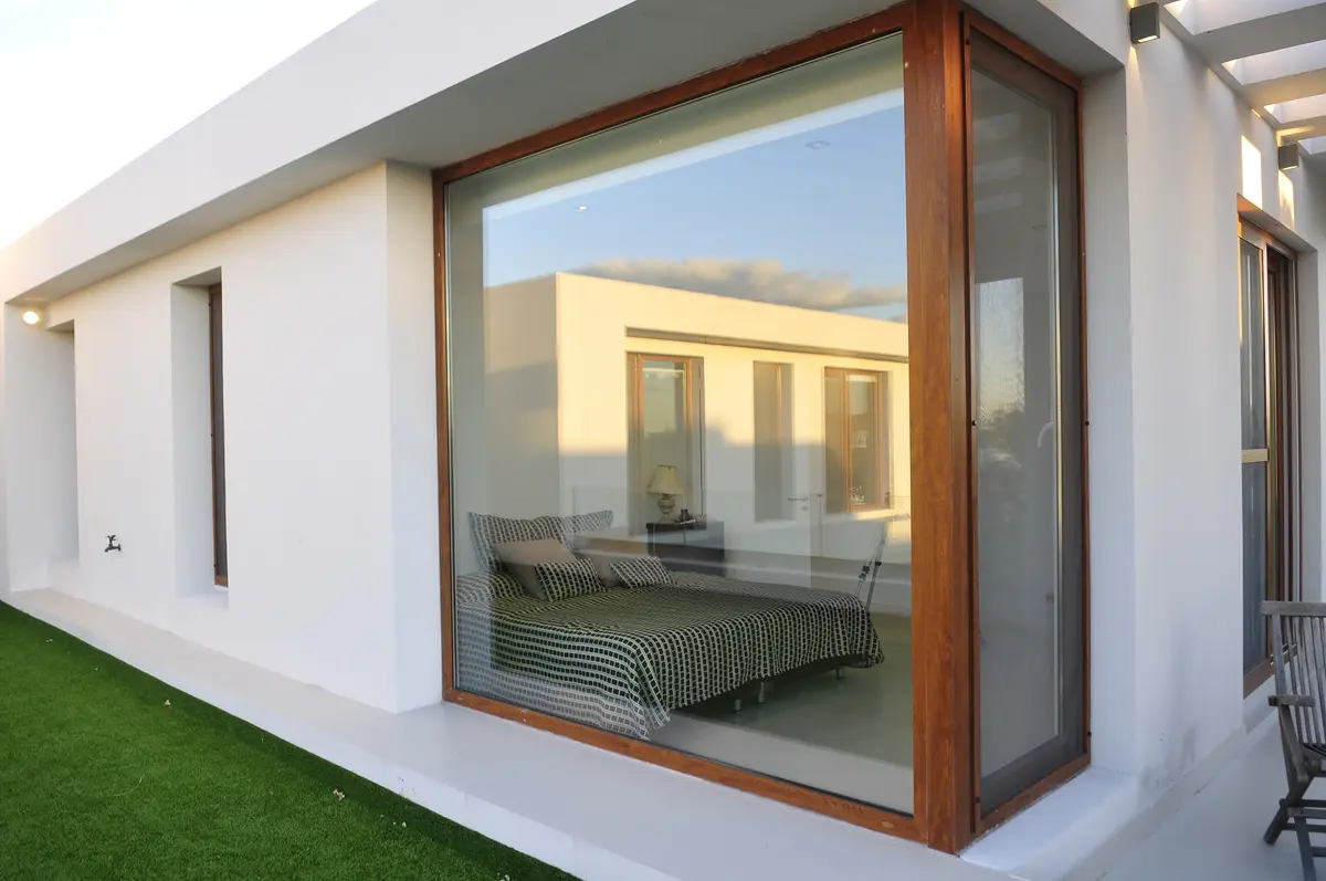 Dormitorio moderno minimalista con gran ventanal reflectante — proyecto CASA GOLF, por Ramirez Arquitectura, en Nordelta