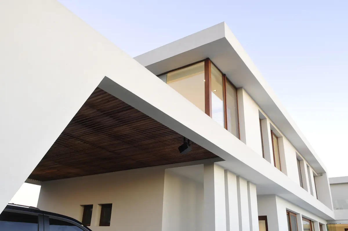 Fachada moderna branca com detalhes em madeira e grandes janelas — projeto CASA GOLF, por Ramirez Arquitectura, em Nordelta