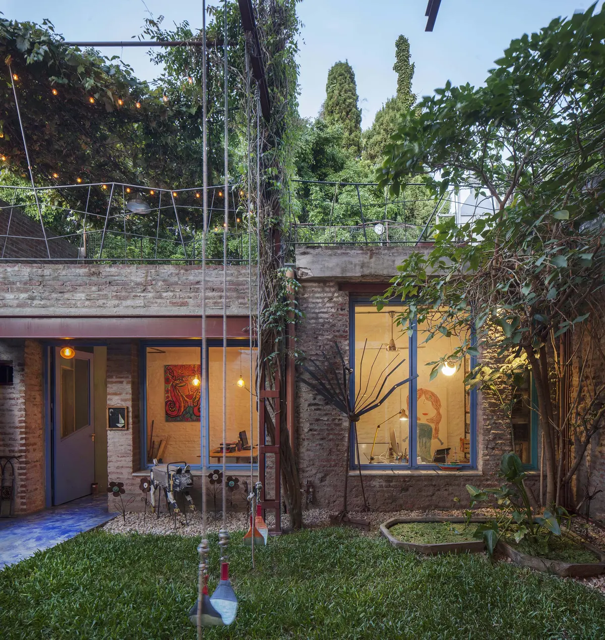 fachada moderna con ladrillo expuesto y vegetación exuberante — proyecto Casa Warnes, por Silvia Soqueff, en CABA