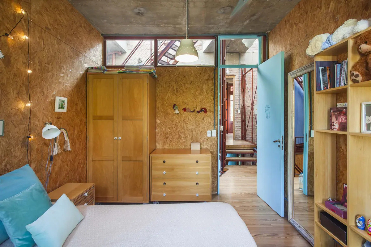 dormitorio rústico con paredes de madera y techo de hormigón — proyecto Casa Warnes, por Silvia Soqueff, en CABA