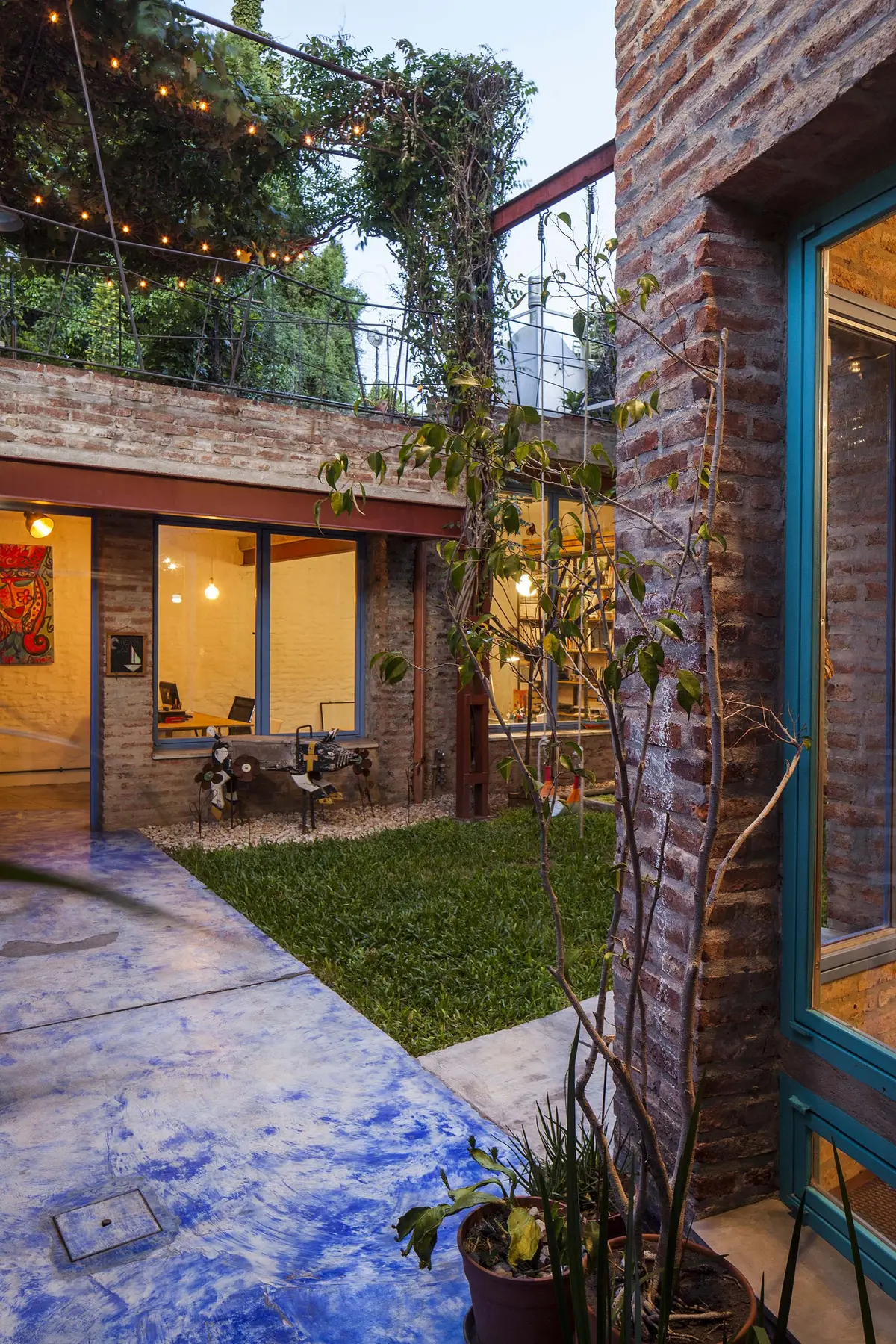 Patio moderno con piso de hormigón azul y ladrillos expuestos — proyecto Casa Warnes, por Silvia Soqueff, en CABA