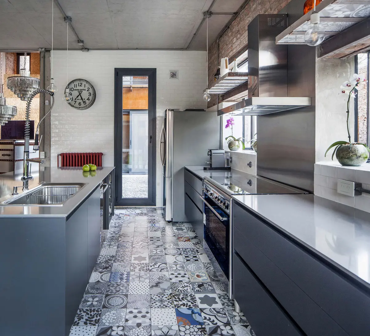 Cocina moderna con isla, azulejos llamativos y gabinetes oscuros — proyecto Casa Lavalle, por Silvia Soqueff, en CABA