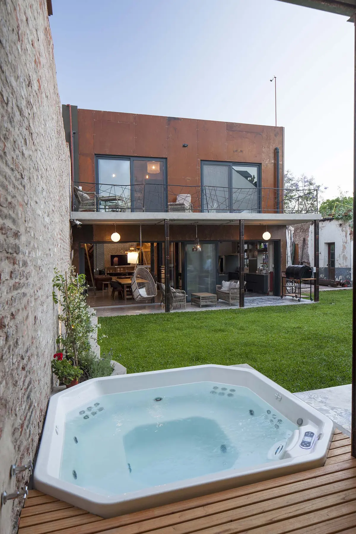Casa moderna industrial com jacuzzi externa e gramado — projeto Casa Lavalle, por Silvia Soqueff, em CABA