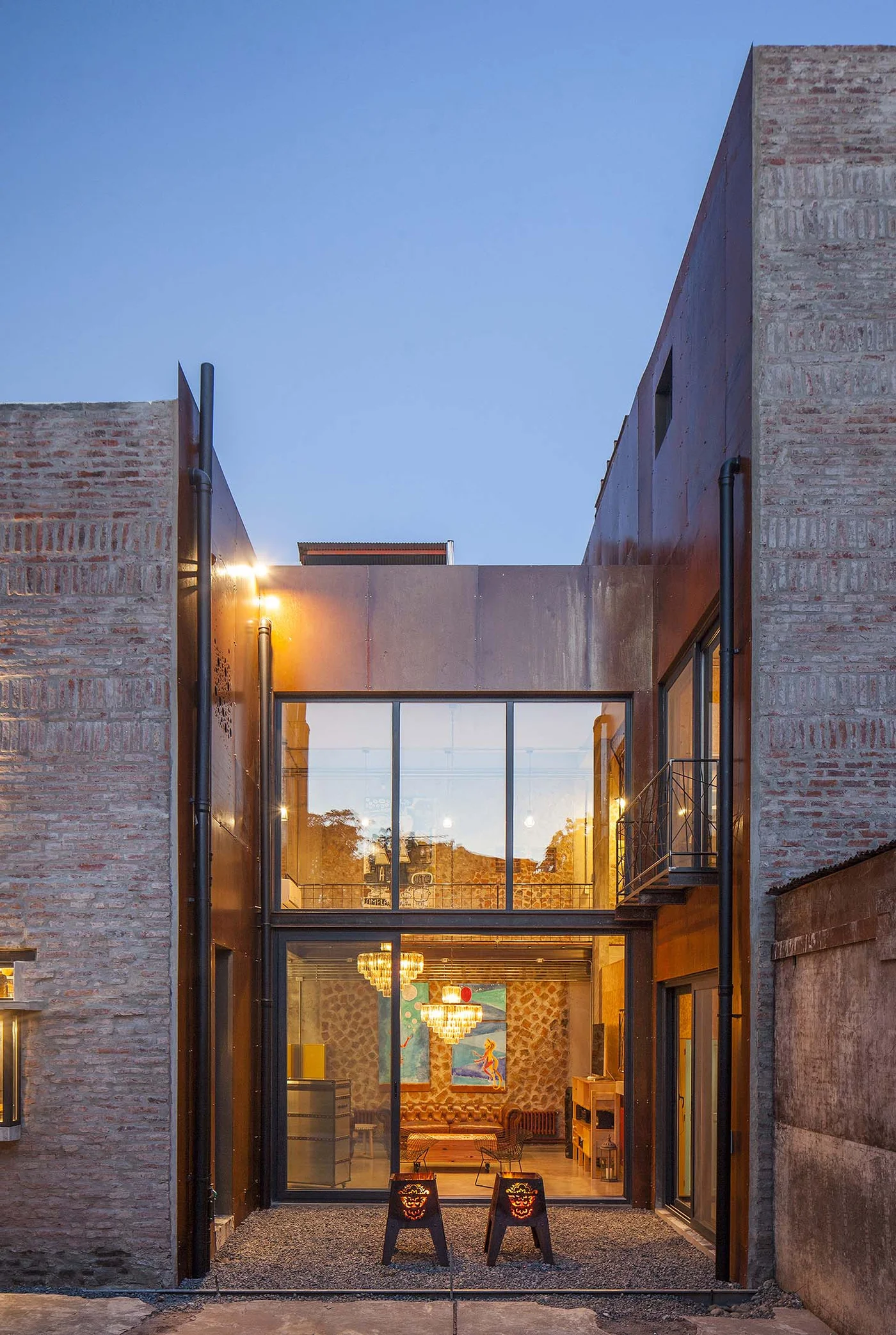 Casa moderna con fachada de ladrillo y metal, amplios ventanales