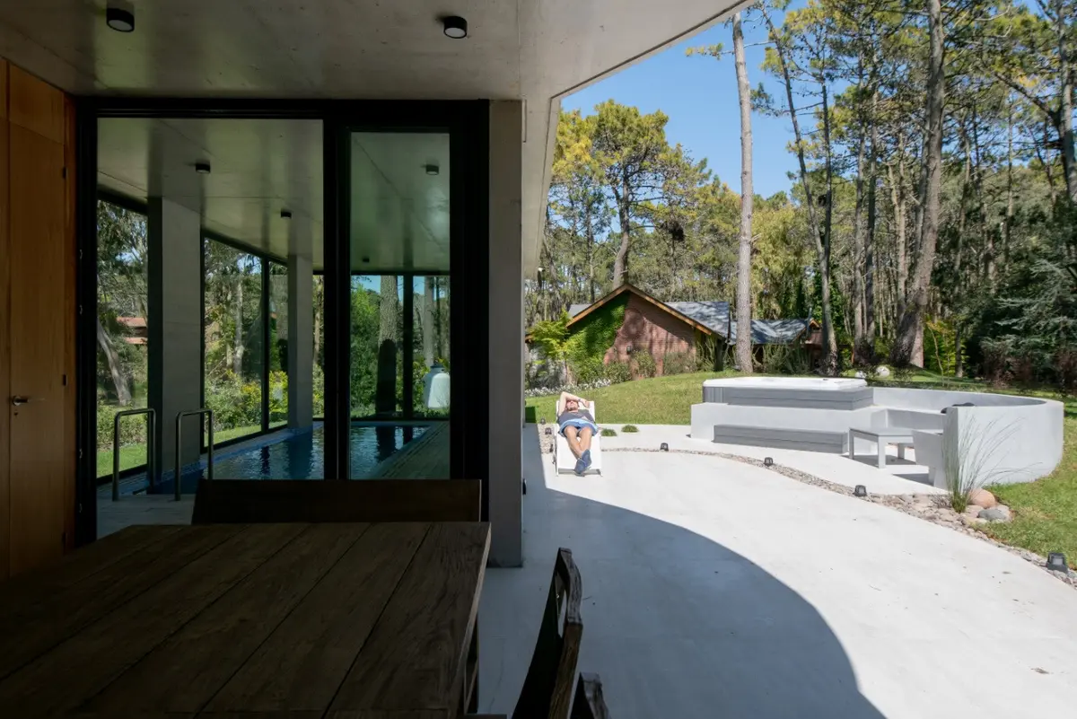 piscina moderna de concreto com deck e rodeada por floresta — projeto Casa G y G, por TAVA Coop, em Cariló