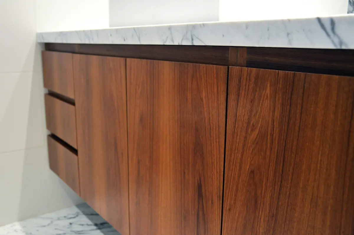 vanitory de madera moderna con mesada de mármol y bacha integrada — proyecto Amenabar, por Bárbara Zoberman Arquitectura, en CABA