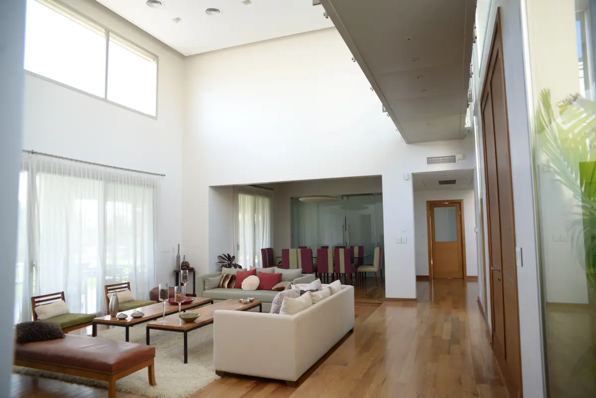 Sala de estar e jantar moderna com janelas amplas e piso de madeira — projeto San Isidro Labrador, por GreenArq - Carolina Faverio, em San Isidro