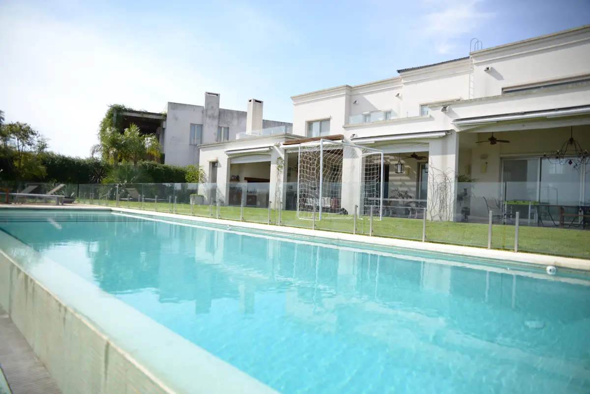 Piscina moderna con deck de madera y fachada blanca — proyecto San Isidro Labrador, por GreenArq - Carolina Faverio , en San Isidro