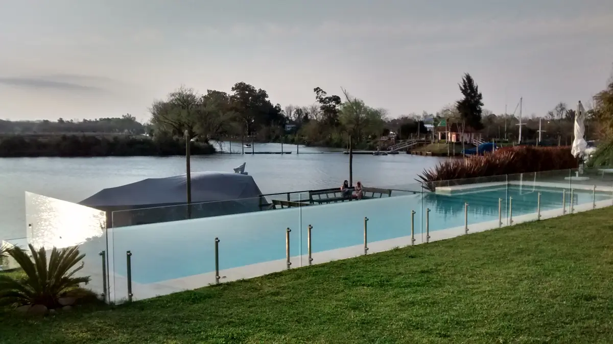 Piscina moderna con valla de vidrio junto al agua — proyecto San Isidro Labrador, por GreenArq - Carolina Faverio , en San Isidro