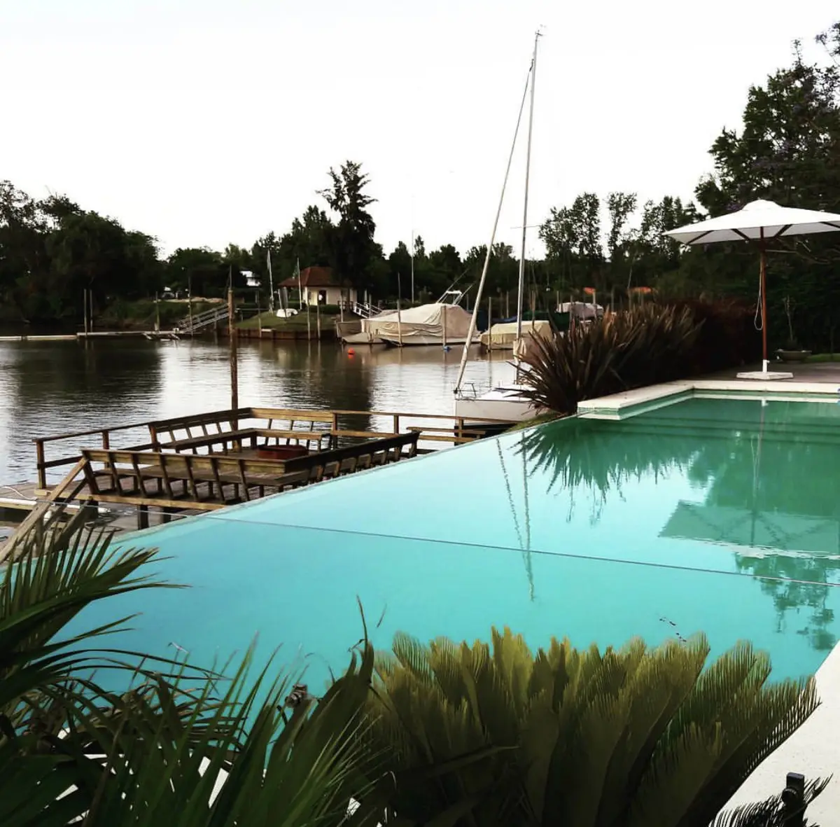 Casa moderna com piscina e iates na doca — projeto San Isidro Labrador, por GreenArq - Carolina Faverio, em San Isidro