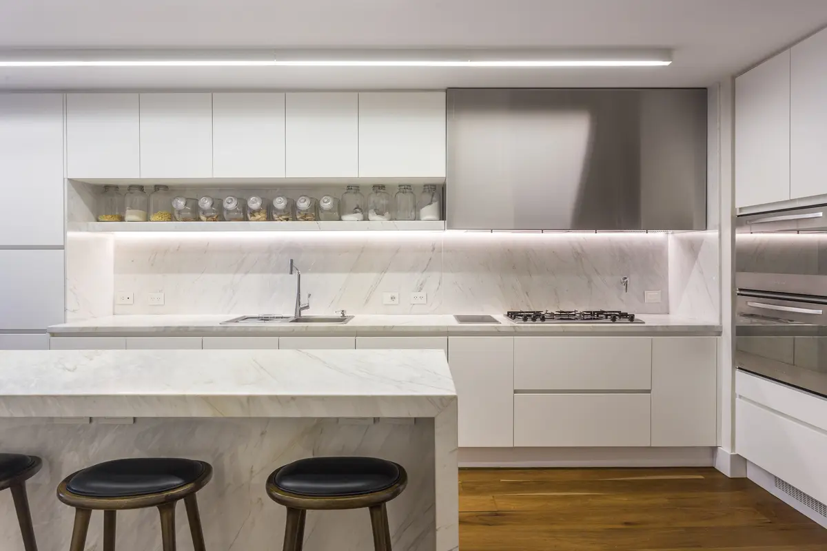 Cocina minimalista con isla, mesada de mármol y taburetes de madera — proyecto The Classic, por BAS Y GARCIA , en San Isidro