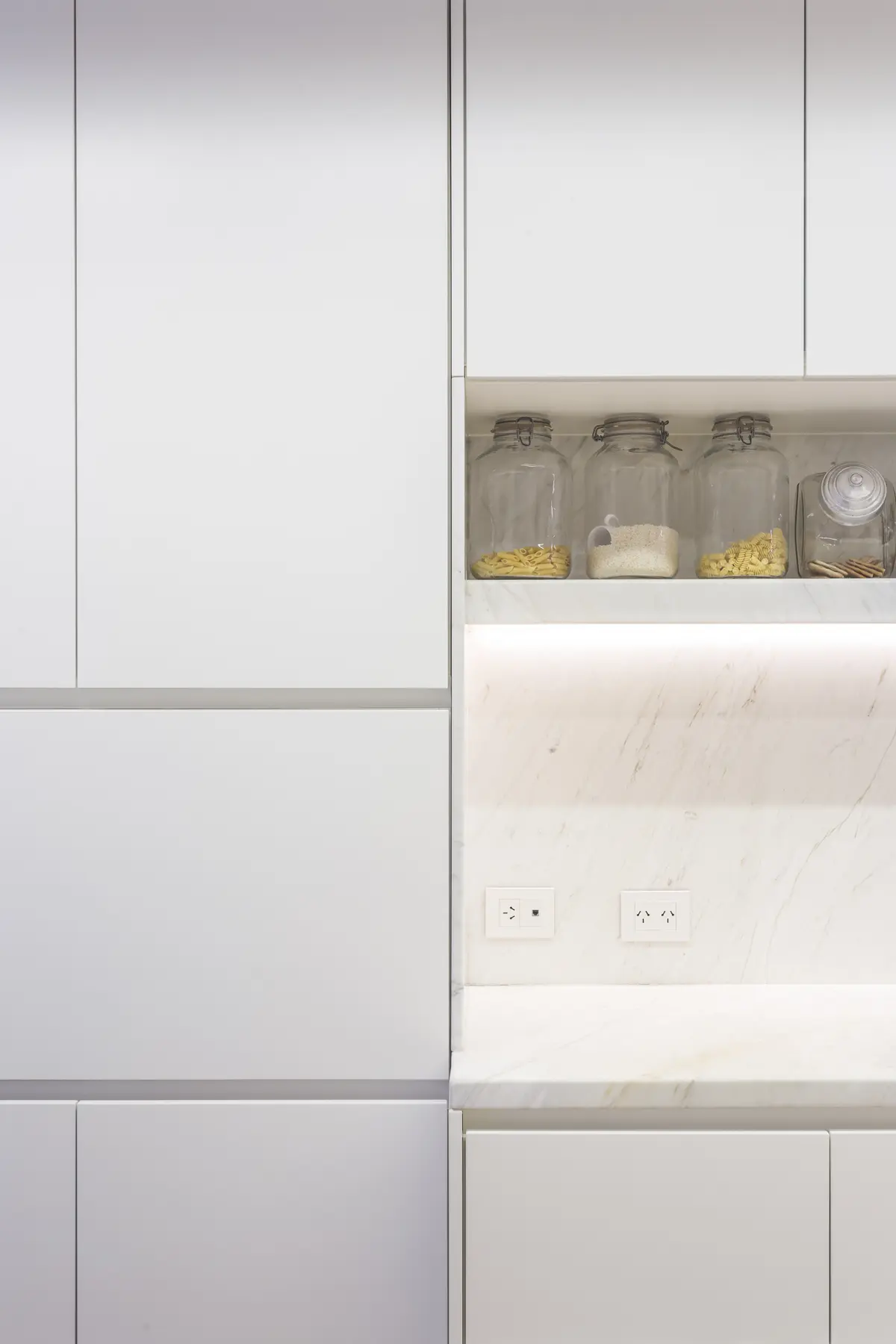 Detalle de cocina minimalista con marmol, repisa abierta y frascos de vidrio — proyecto The Classic, por BAS Y GARCIA , en San Isidro