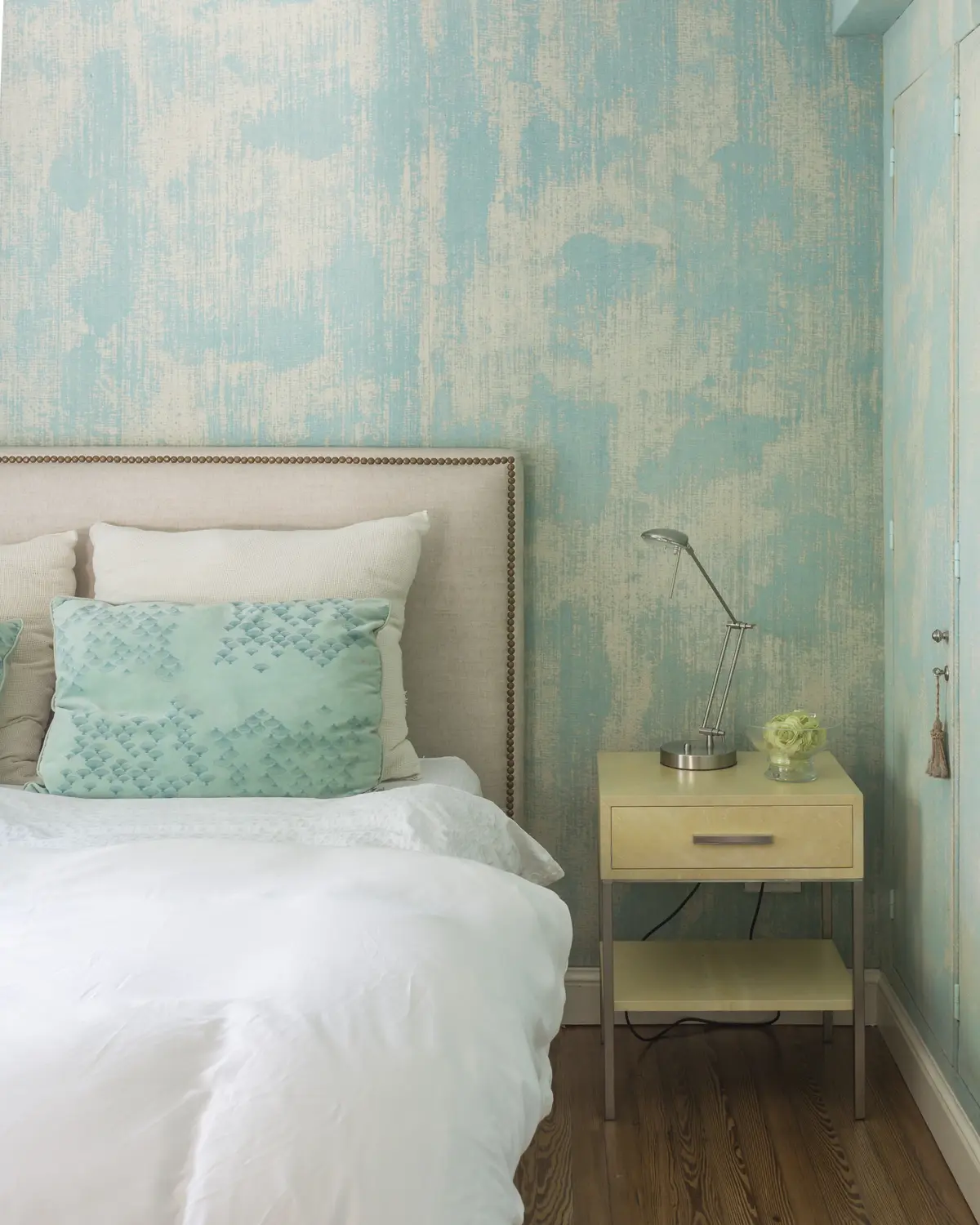 Dormitorio minimalista con cama tapizada, pared texturada verde agua y mesita auxiliar — proyecto The Classic, por BAS Y GARCIA , en San Isidro