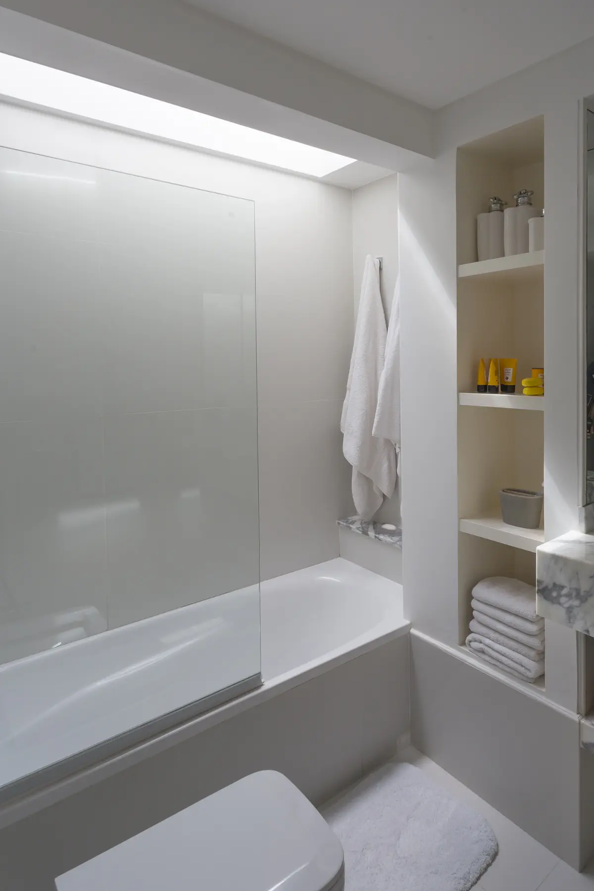 Baño minimalista con ducha vidrio y nicho beige con productos — proyecto The Classic, por BAS Y GARCIA , en San Isidro