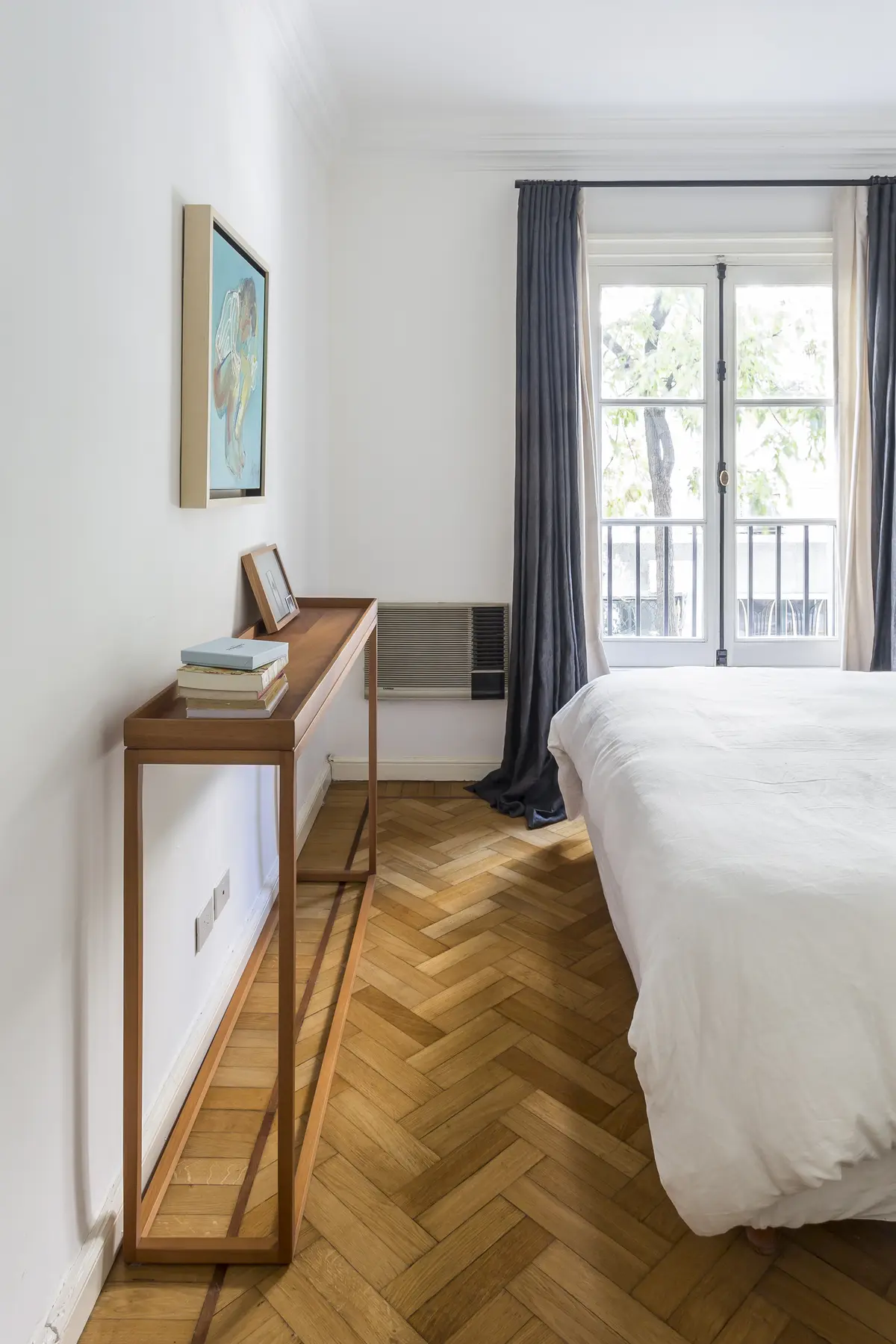 dormitorio minimalista con escritorio de madera y ventanal a balcón — proyecto Arenales, por BAS Y GARCIA , en Recoleta