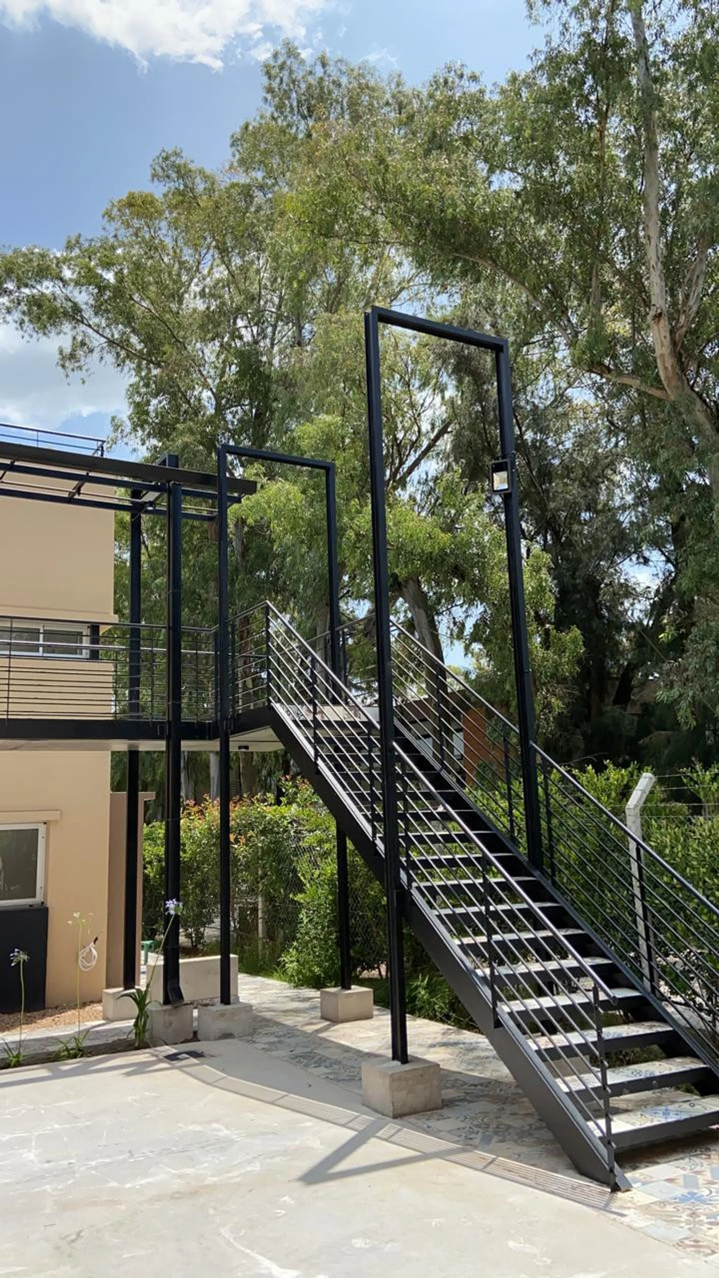 Escalera metálica negra con barandal en vivienda moderna exterior