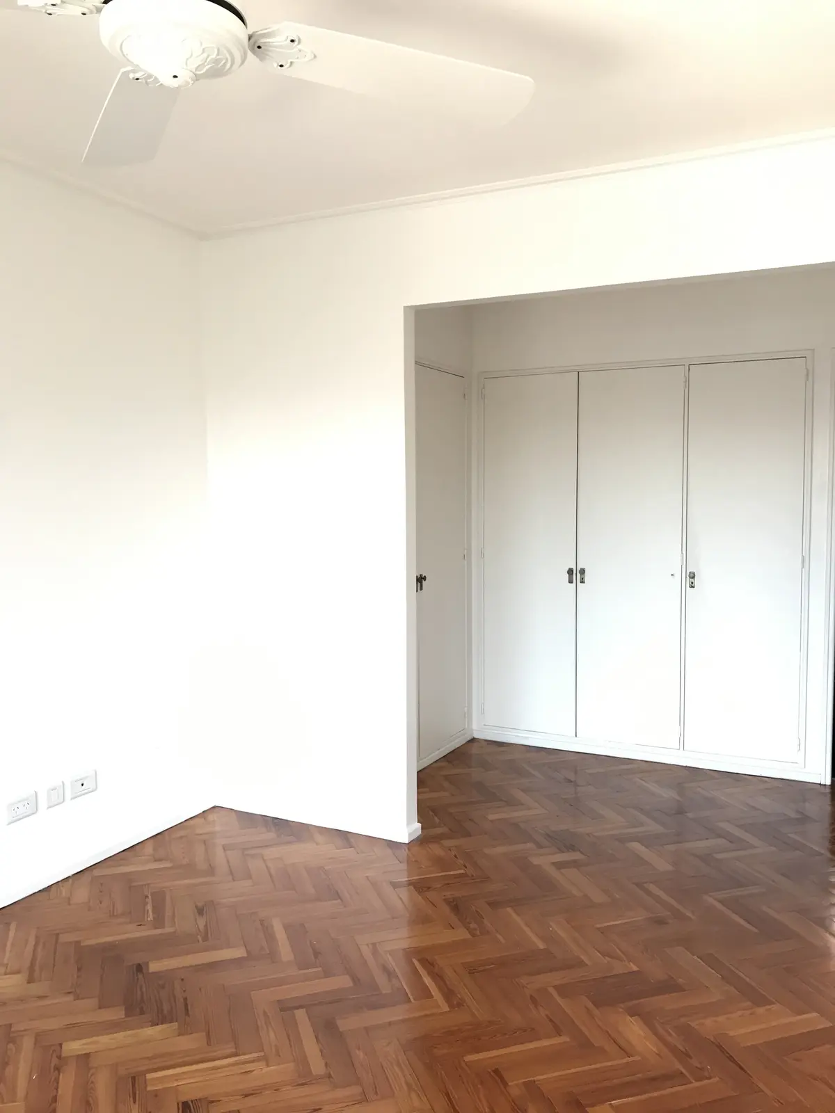 Dormitorio minimalista con piso de parquet chevron y placards blancos — proyecto Peña, por Biaus Pieres Arquitectura, en Recoleta
