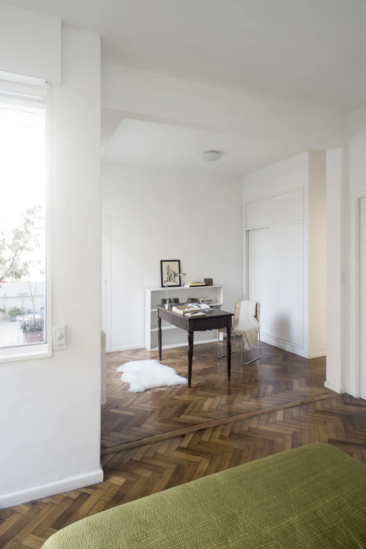 Dormitorio luminoso con escritorio, piso de madera y vista amplia — proyecto Departamento Barrancas, por Ekaterina Kunzel Arquitecta, en Belgrano