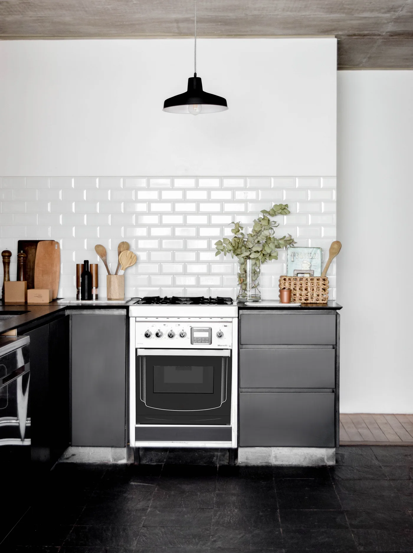 Cocina minimalista con mesada negra, azulejos blancos y estufa central
