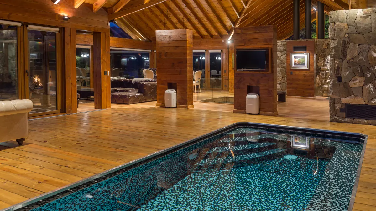 Piscina interior moderna con vigas de madera y piedra — proyecto Casa Villa La Angostura, por Sidoni & Asociados, en Villa La Angostura