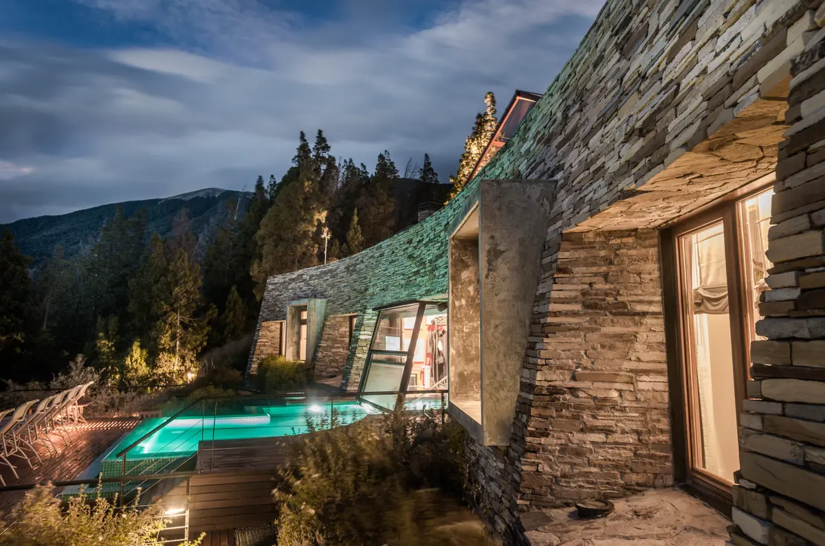 Exterior moderno con piscina infinita en montaña, noche — proyecto Casa Villa La Angostura 2, por Sidoni & Asociados, en Villa La Angostura