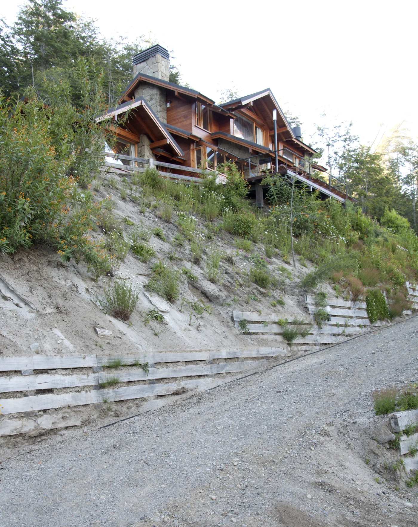 casa de madera en ladera con muros de contención