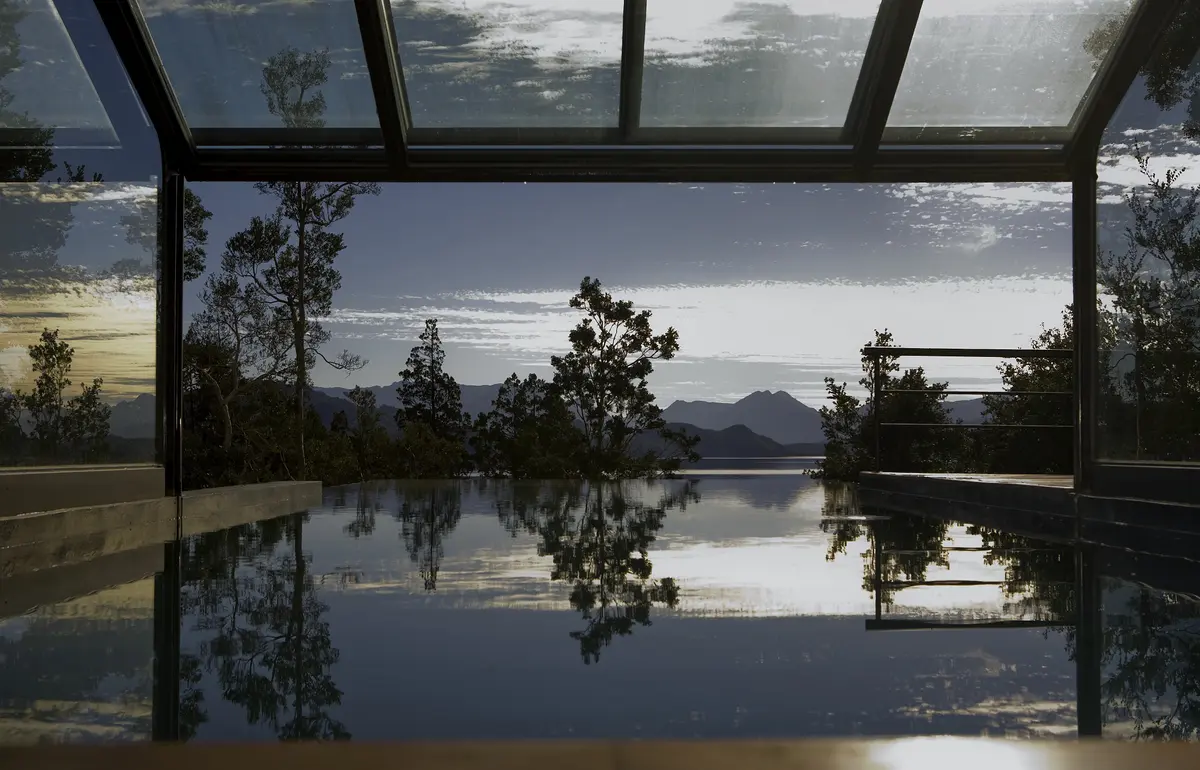 piscina infinita con vista a la montaña y techo de cristal — proyecto Casa Muelle de Piedra, por Sidoni & Asociados, en Villa La Angostura