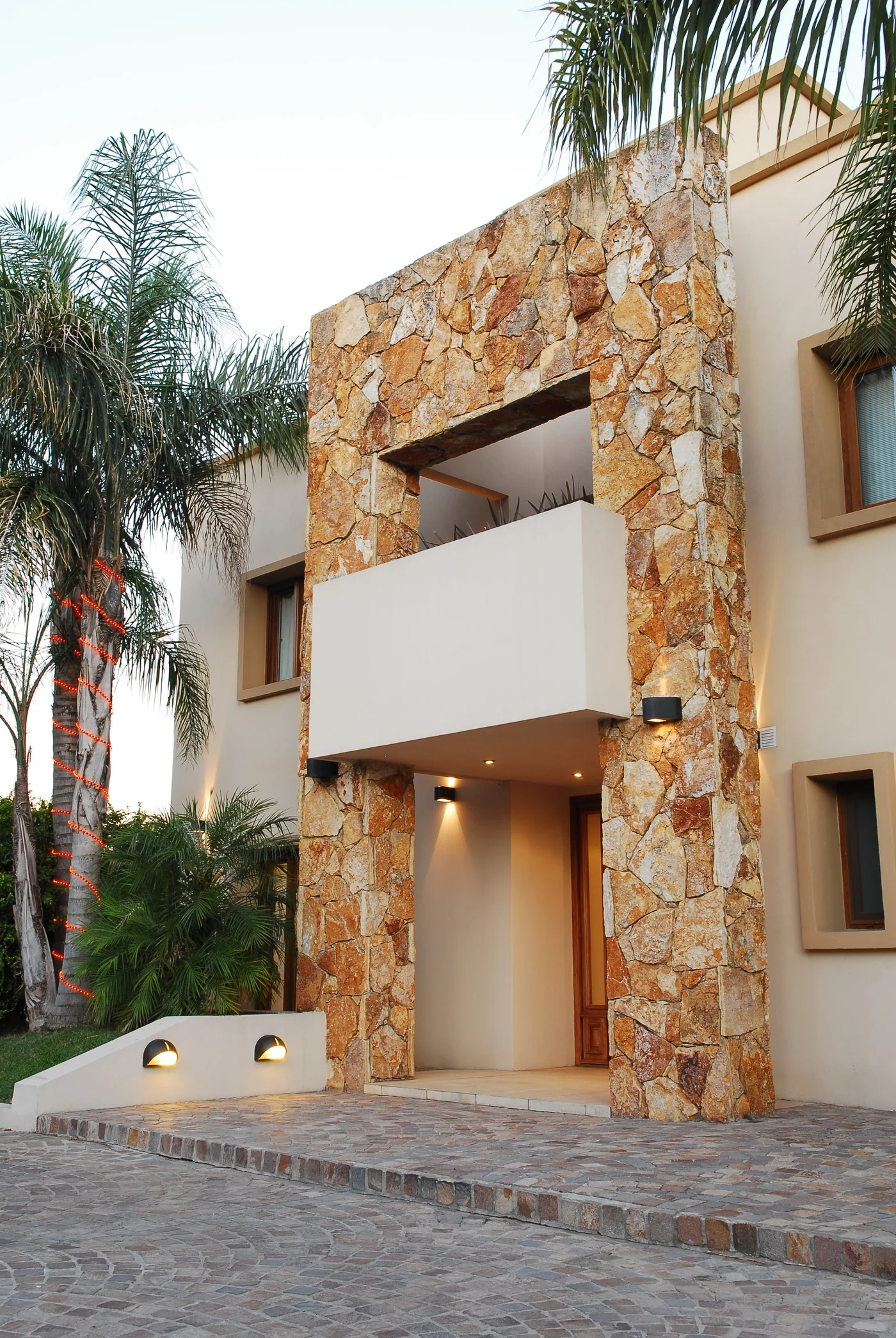 Fachada moderna con revestimiento de piedra natural y vegetación