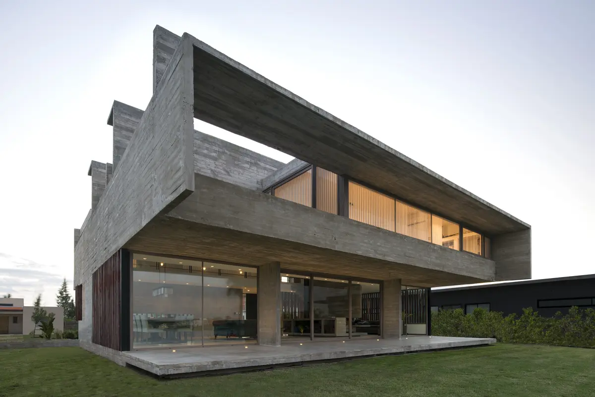 Fachada moderna de concreto com grandes janelas e balanço — projeto Casa 10, por Luciano Kruk