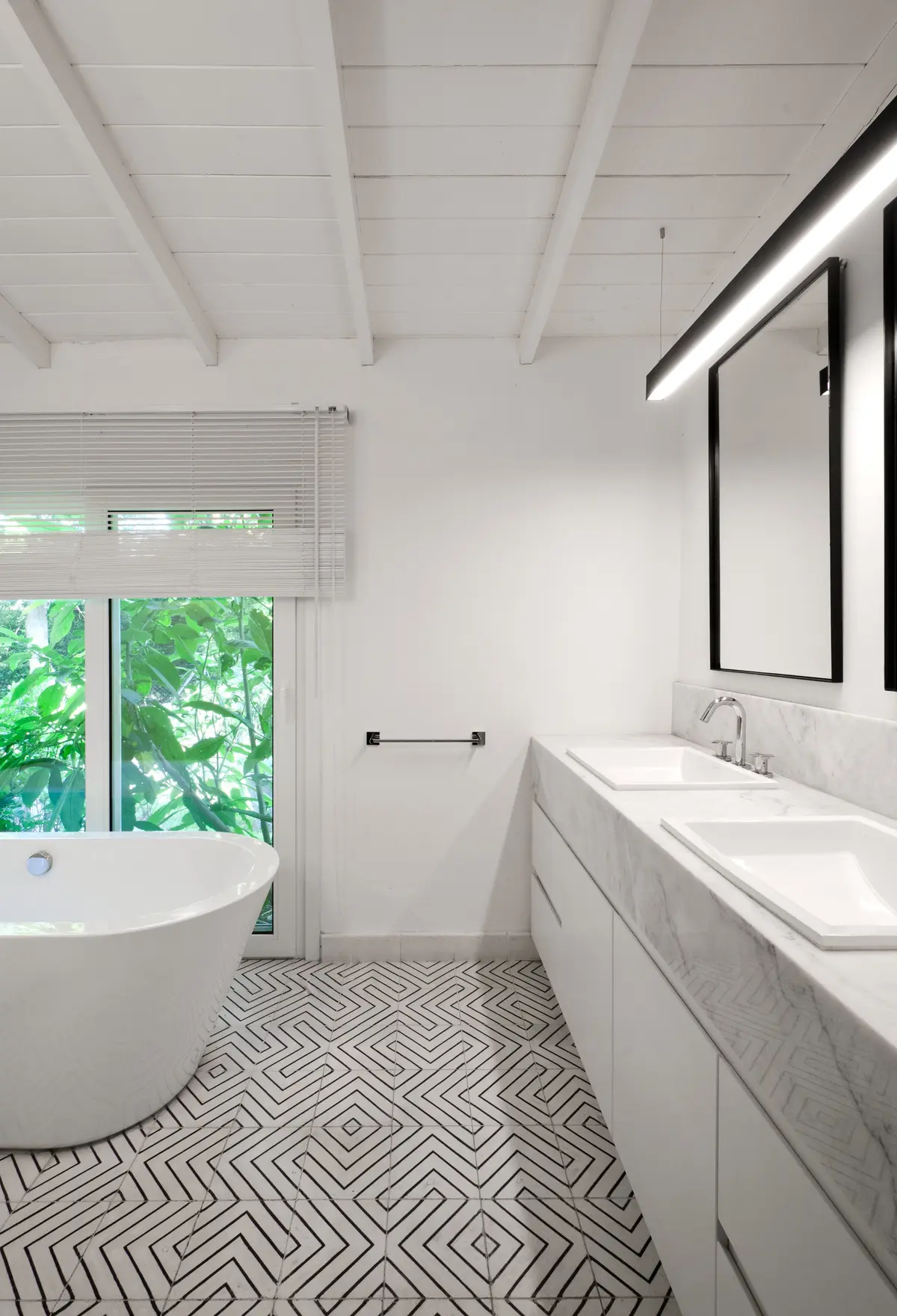 Baño moderno con bañera exenta y suelo geométrico — proyecto Casa BA, por Estudio Dado, en Pilar