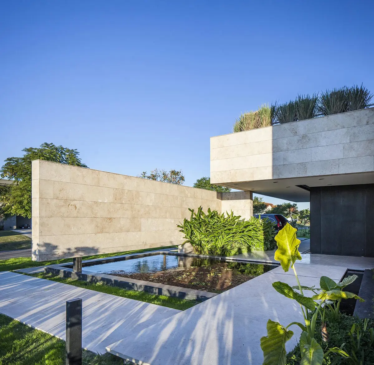 Fachada moderna com piscina e vegetação exuberante — projeto BV, por Remy Arquitectos