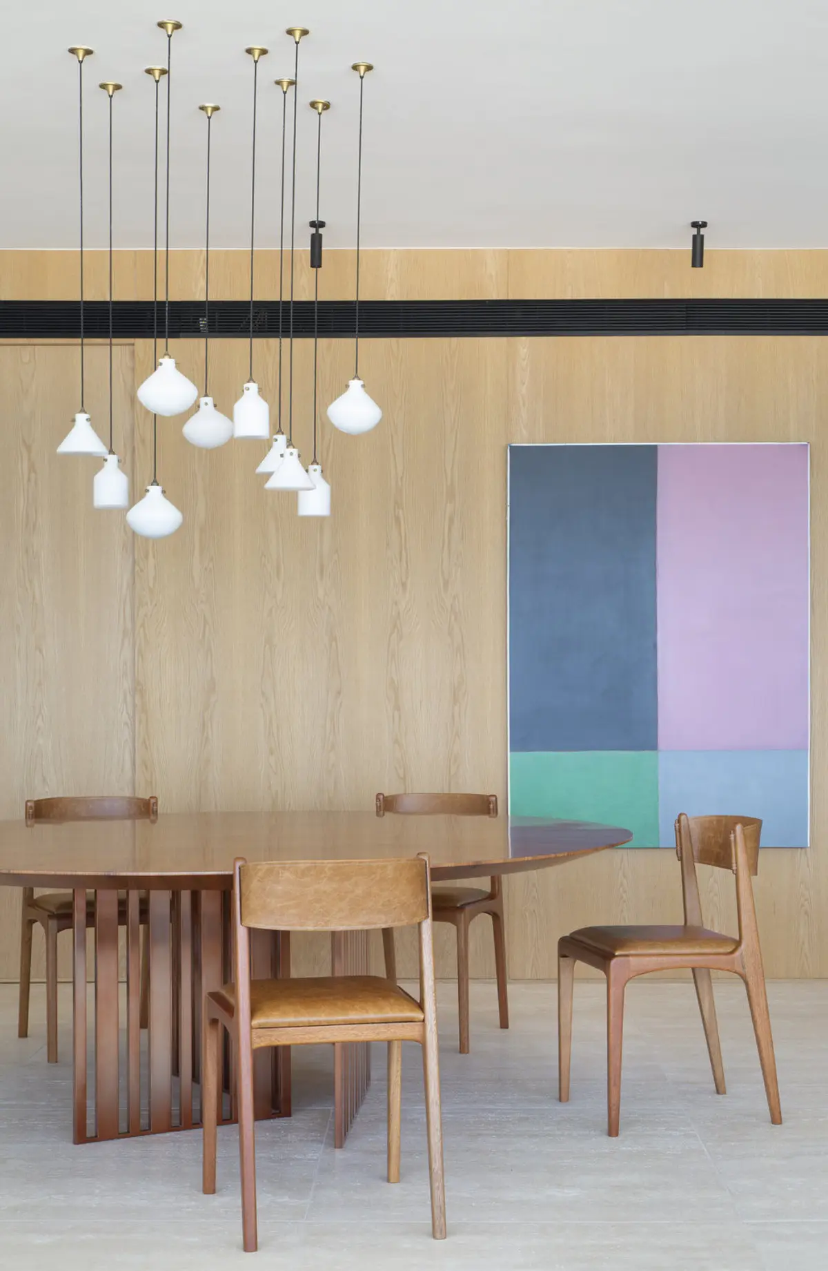 Comedor minimalista con mesa redonda, sillas de madera y lámparas colgantes — proyecto PS House, por Studio Ro-ca