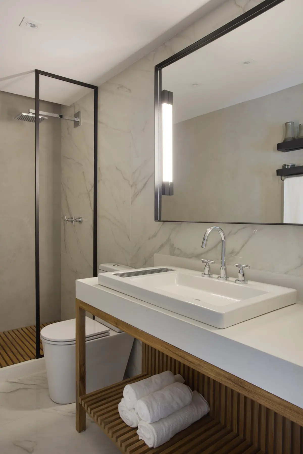 Baño moderno con mármol, mueble de madera y espejo con marco negro — proyecto Decorado Latitud, por Studio Ro-ca